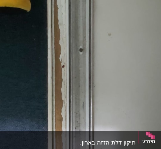 מסילת מתכת על קיר לבן עם סימני שחיקה
